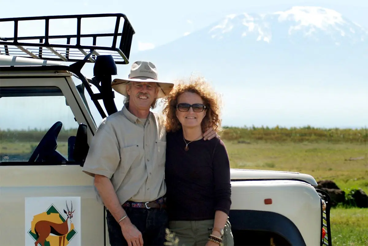 Rick Thomson and Judi Wineland beside a Thomson vehicle with snow-capped Kilimanjaro behind
