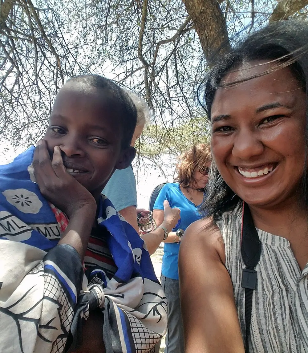 Smiling Thomson staff member taking a selfie with a Maasai girl