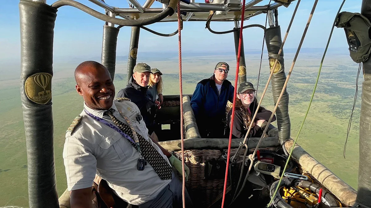 Pilot and passengers in a hot air balloon basket floating high above the plains
