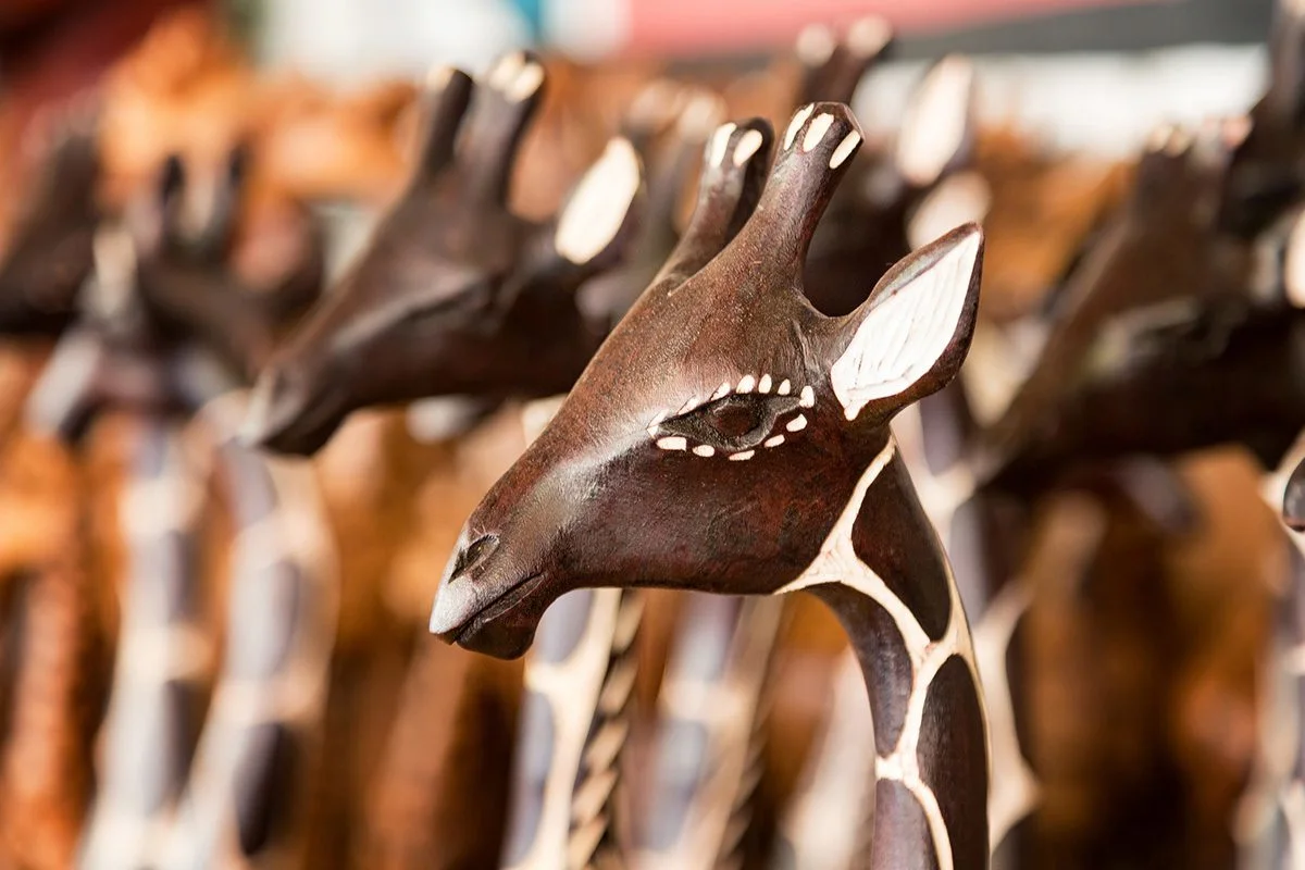 Row of carved wooden giraffe figurines