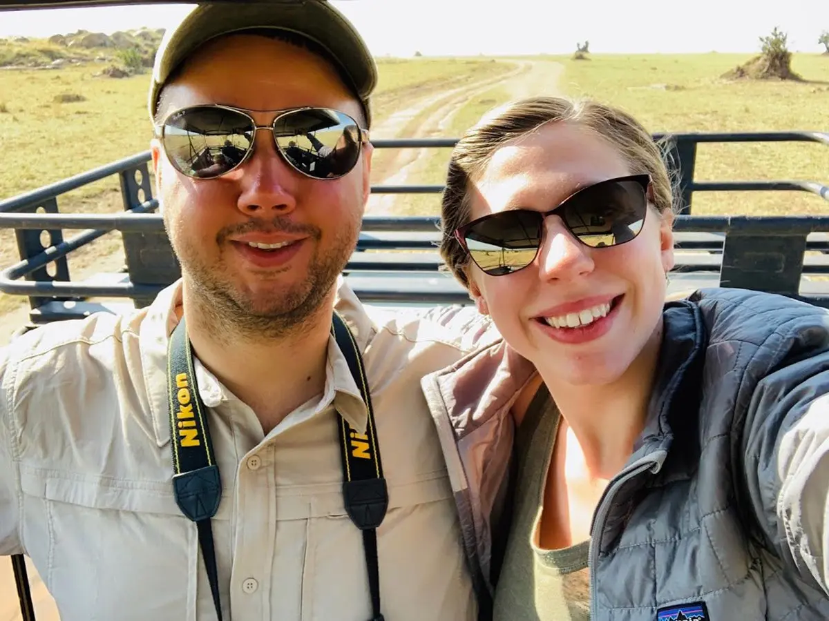 Smiling couple taking a selfie in an open safari vehicle