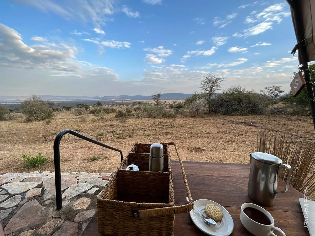Morning coffee basket and mug on a tent deck overlooking the plains