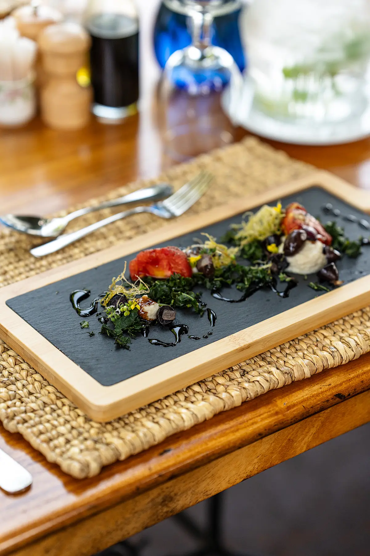 Salad garnished with flowers served on a slate board at Gibb's Farm
