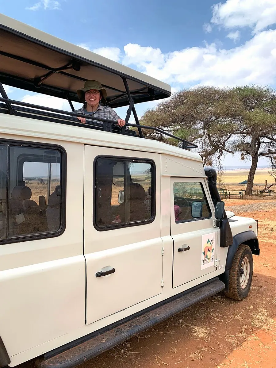 Guest standing in the roof hatch of a safari vehicle