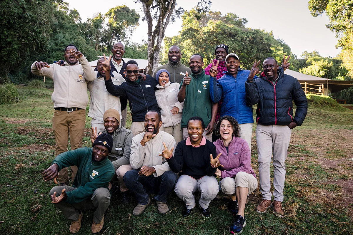 Rose Ngilisho with a group of smiling camp staff posing outdoors