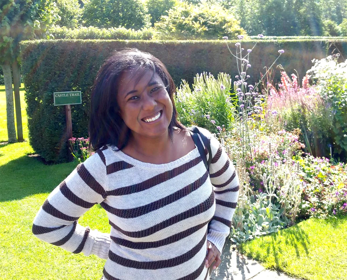 Portrait of Angela Woods smiling in a flower garden