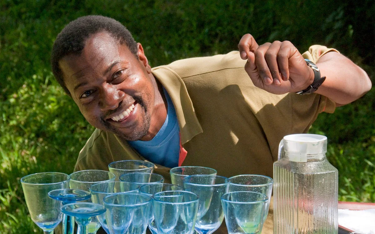 Smiling staff member arranging blue glasses at Ngorongoro Nyumba