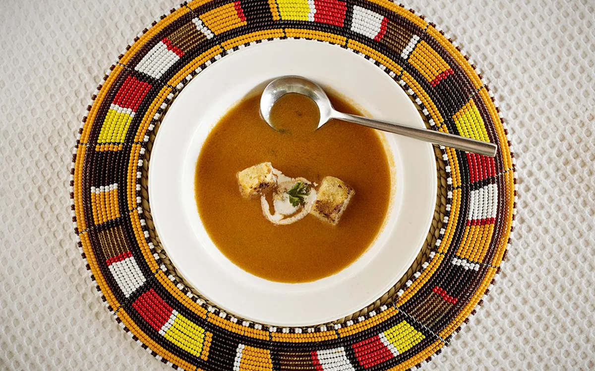 Bowl of soup on a colorful beaded placemat at Tarangire Nyumba