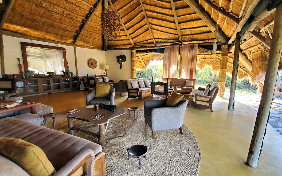 Inside the thatched lounge with sofas and armchairs at Serengeti Nyumbas