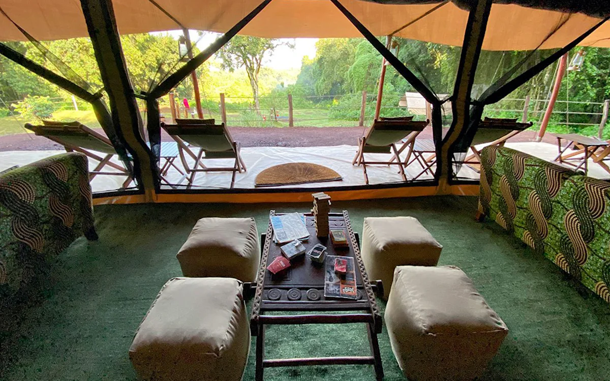 Lounge tent seating with a low table looking out over the grounds at Ngorongoro Nyumba