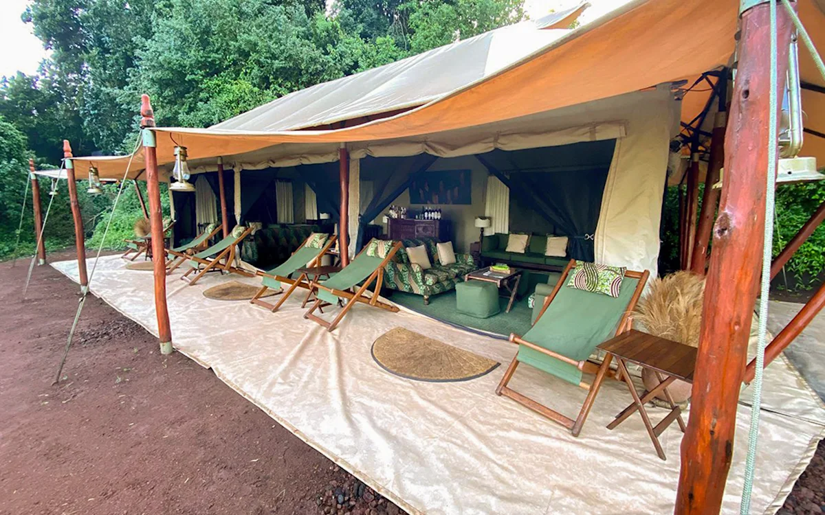 Lounge tent with green deck chairs on its veranda at Ngorongoro Nyumba