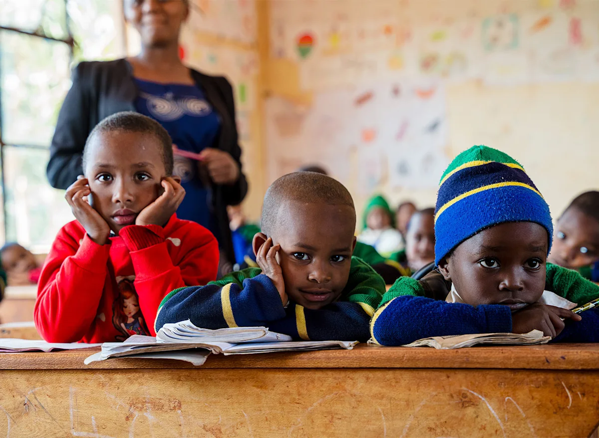 Young students resting their chins on their hands at a classroom desk