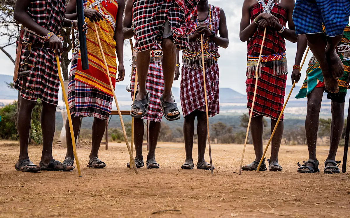 Maasai men jumping during a traditional dance, shown from the knees down