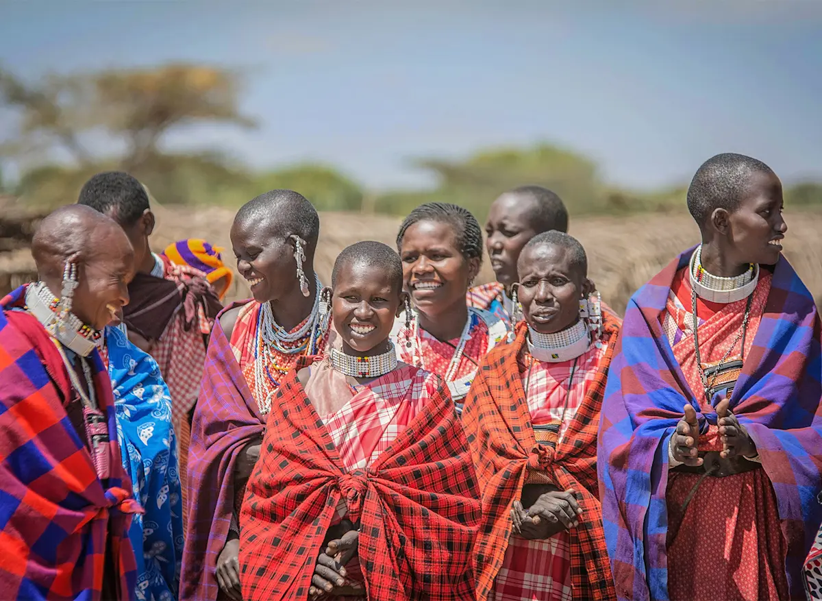 Group of smiling Maasai women in colorful shukas and beaded jewelry, Eastern Serengeti