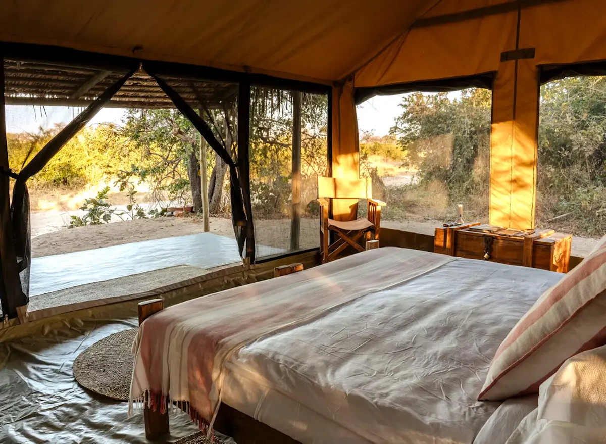 Guest tent interior with a bed looking out to the bush at Kigelia Ruaha