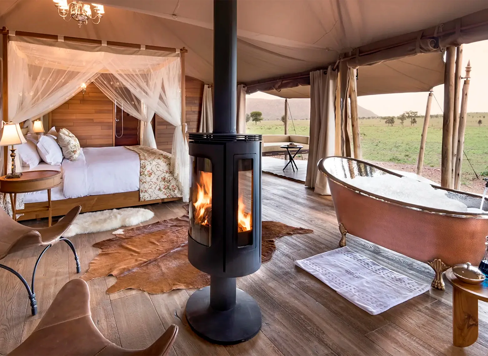 Tented suite with a copper bathtub, wood stove and four-poster bed at Nyaruswiga Safari Camp