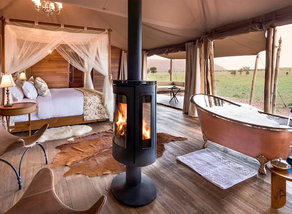 Tented suite with a copper bathtub, wood stove and four-poster bed at Nyaruswiga Safari Camp