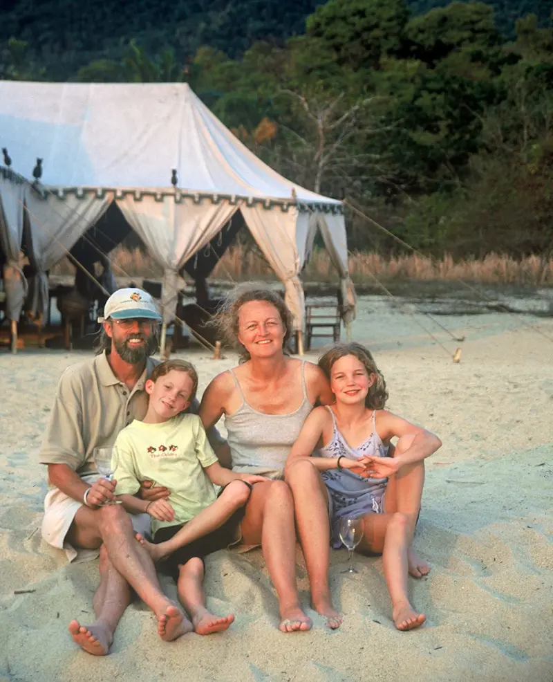 Rick Thomson, Judi Wineland and family sitting on a sandy beach in front of a tent at Mahale