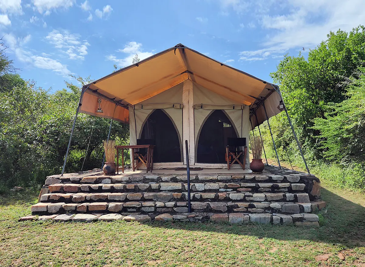 Canvas safari tent on a raised stone platform with steps in the Eastern Serengeti