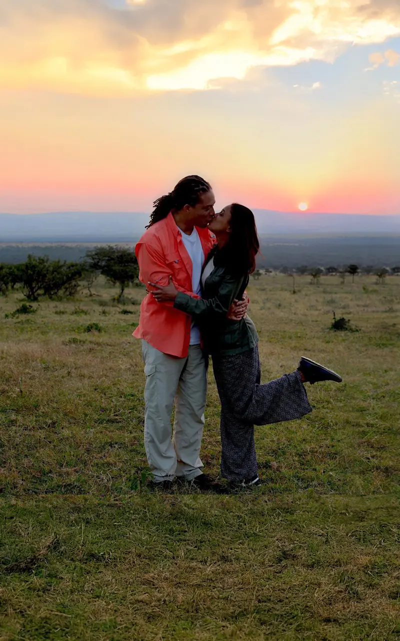 Couple kissing on the savanna at sunset