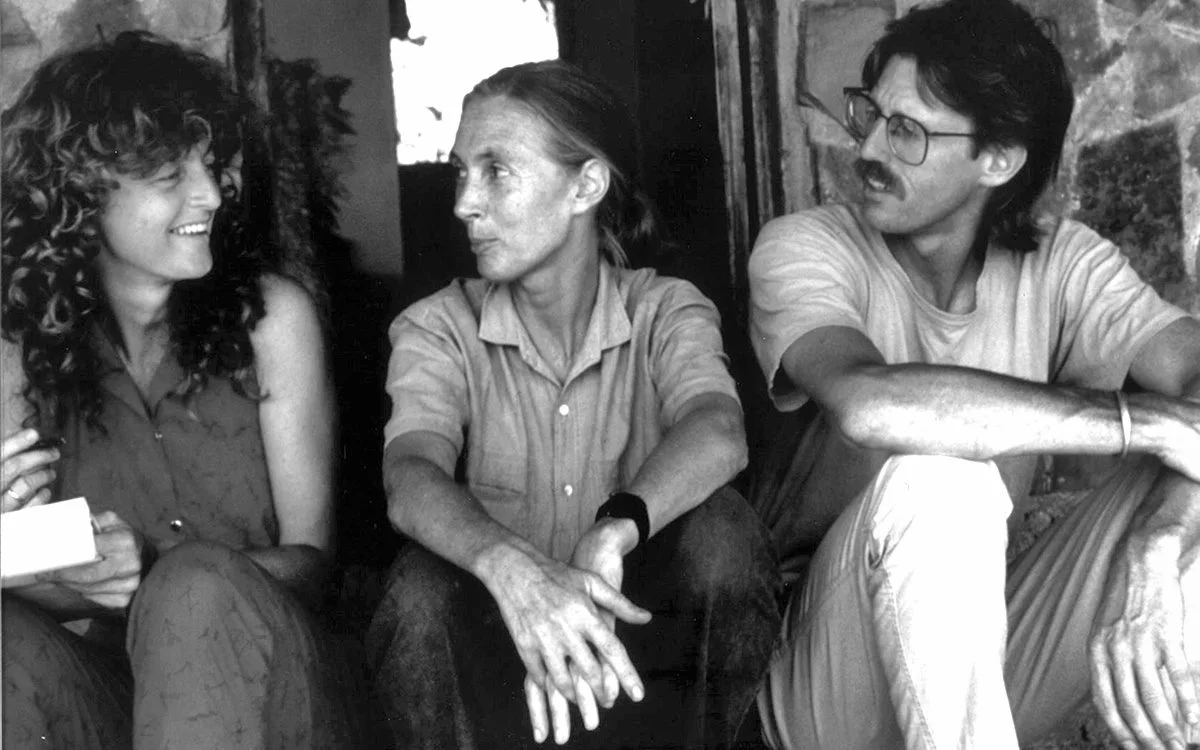 Black-and-white photo of Judi Wineland and Rick Thomson sitting with Jane Goodall