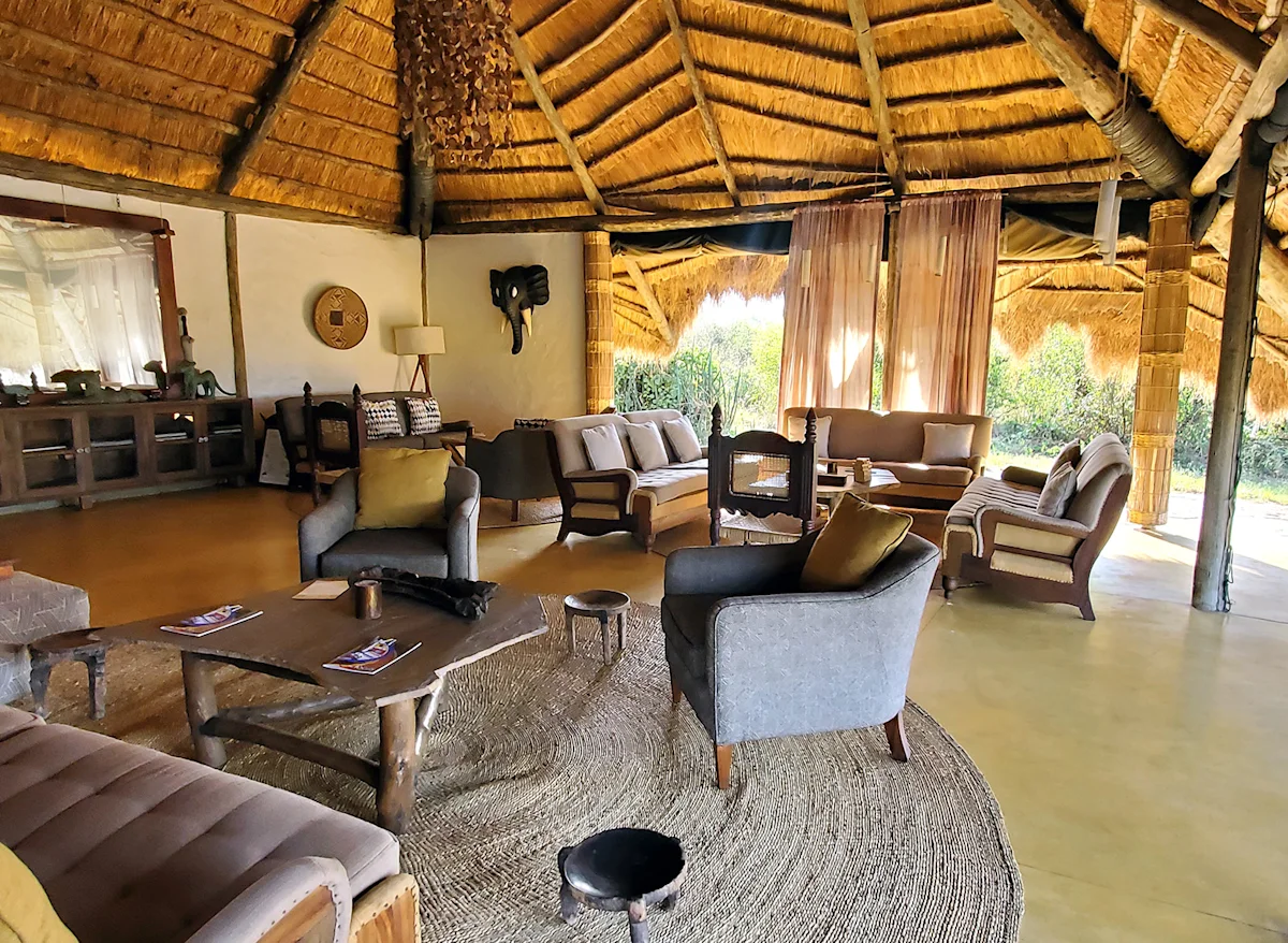 Inside the thatched lounge with sofas and armchairs at a Nyumba camp