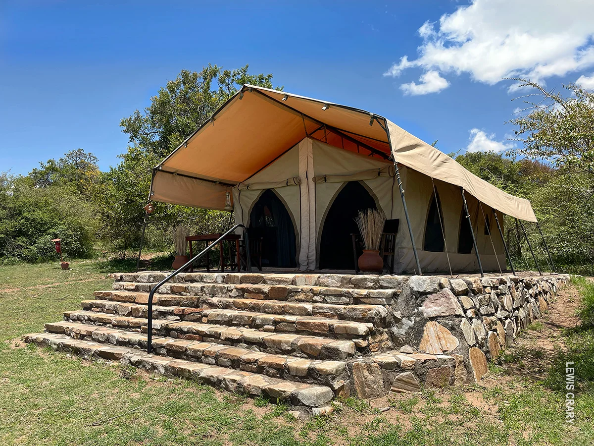Canvas safari tent on a raised stone platform with steps