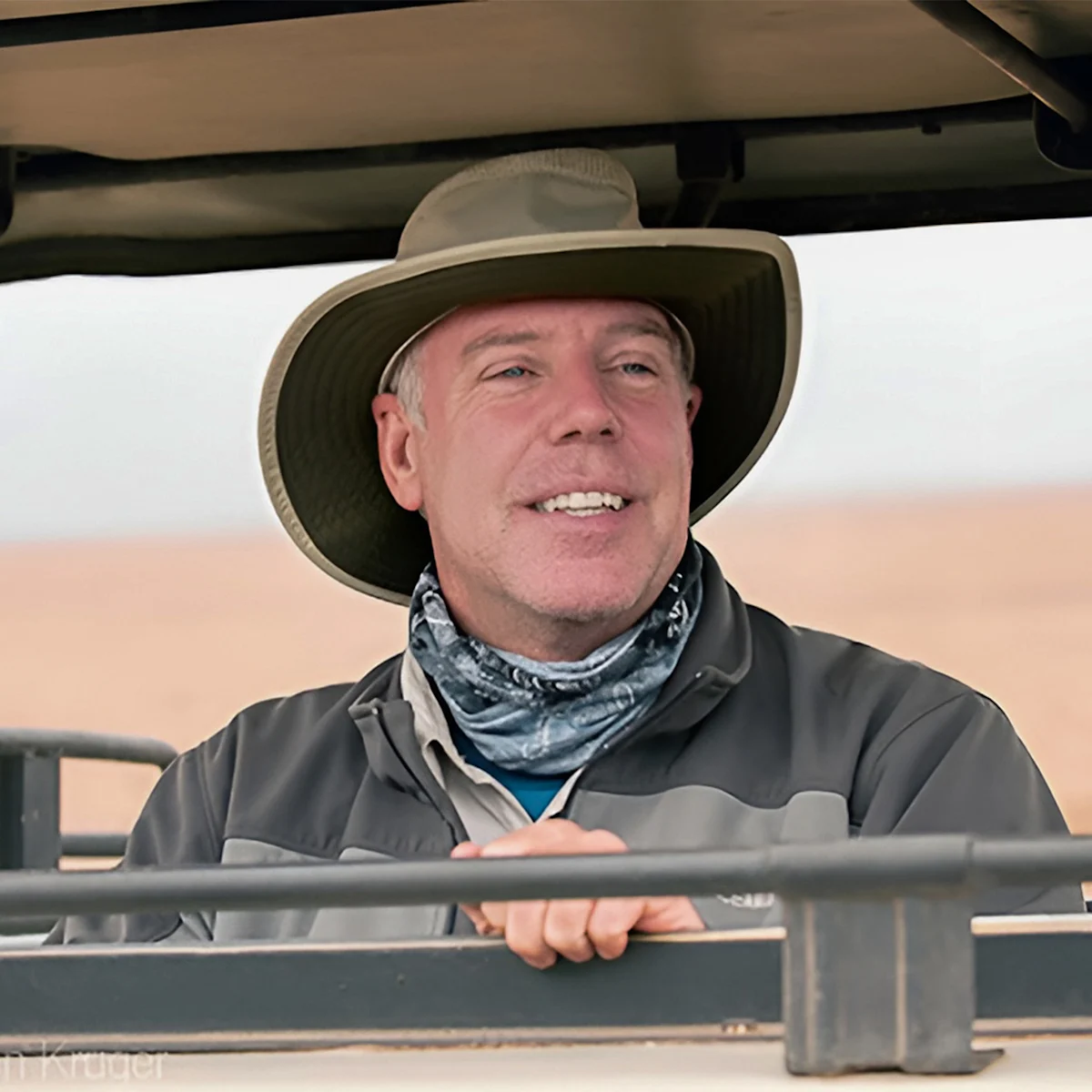 Portrait of photographer Randy Hanna in a wide-brimmed hat in a safari vehicle