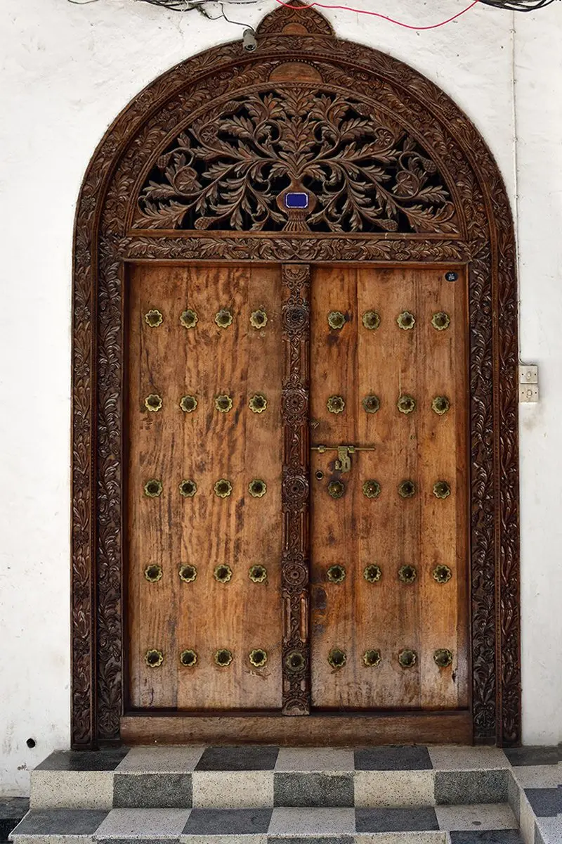 Ornately carved wooden Zanzibar door with brass studs