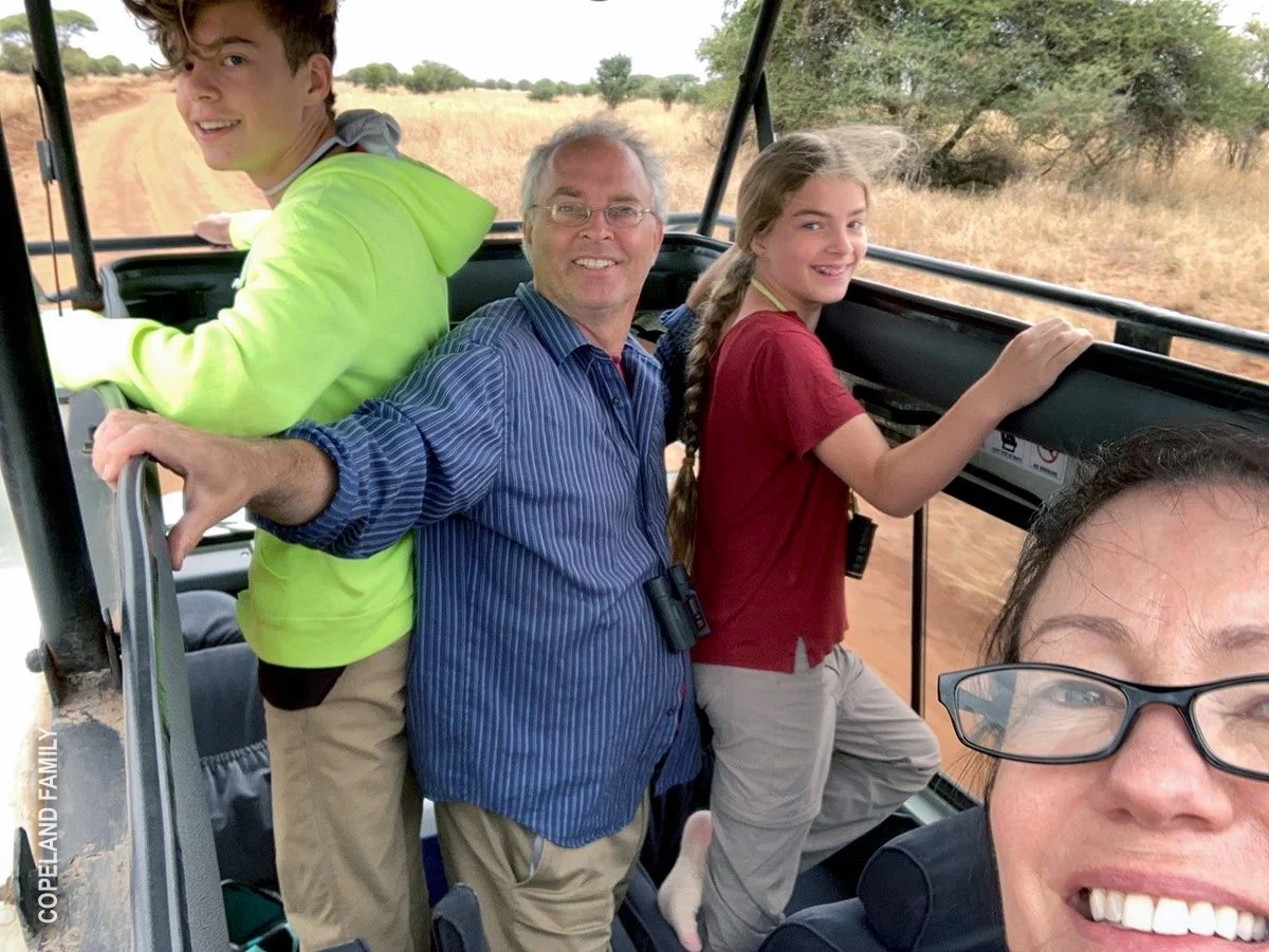 Family taking a selfie while standing in an open safari vehicle