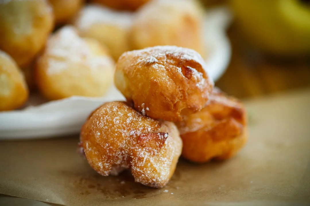 Sugar-dusted fried pastries on a plate