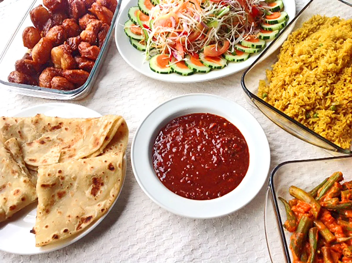 Tanzanian meal of chapati, spiced rice, salad, green beans, and a red sauce
