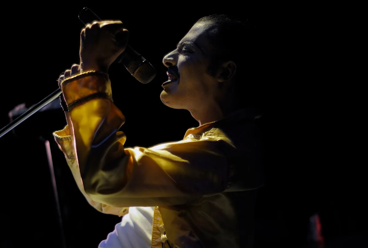Freddie Mercury, born in Zanzibar, performing on stage in a yellow jacket