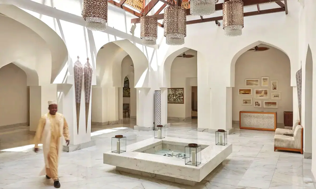 Bright lobby with white arches and a central fountain at Park Hyatt Stone Town