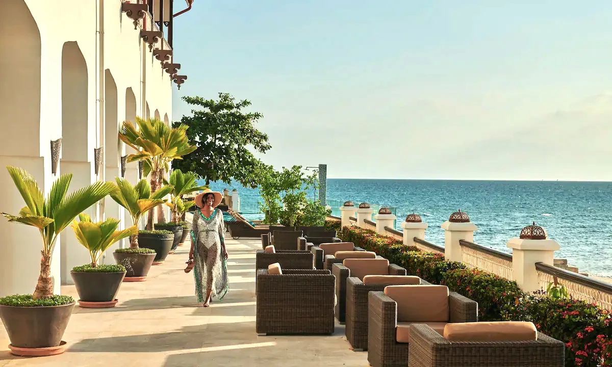 Seafront terrace with lounge seating and potted palms at Park Hyatt Stone Town