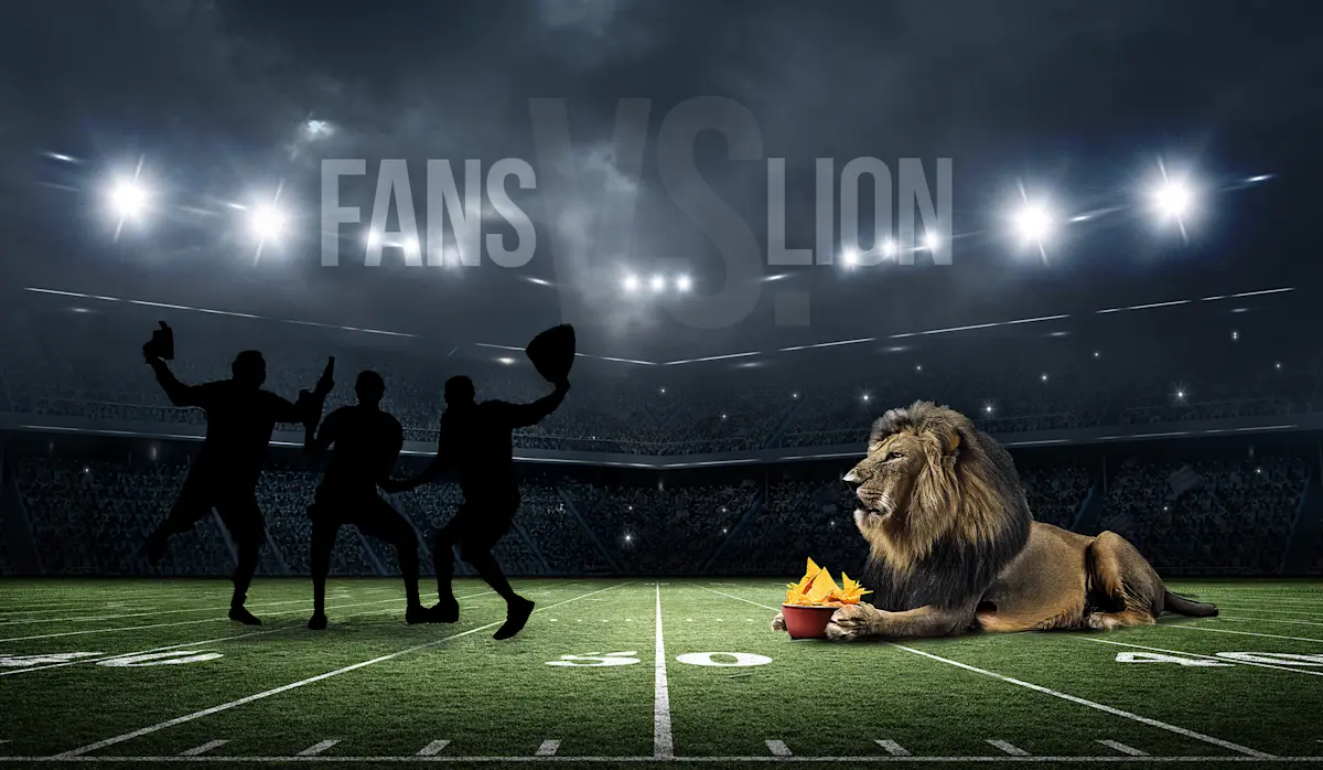 Silhouetted football fans cheering beside a lion lying by a bowl of chips