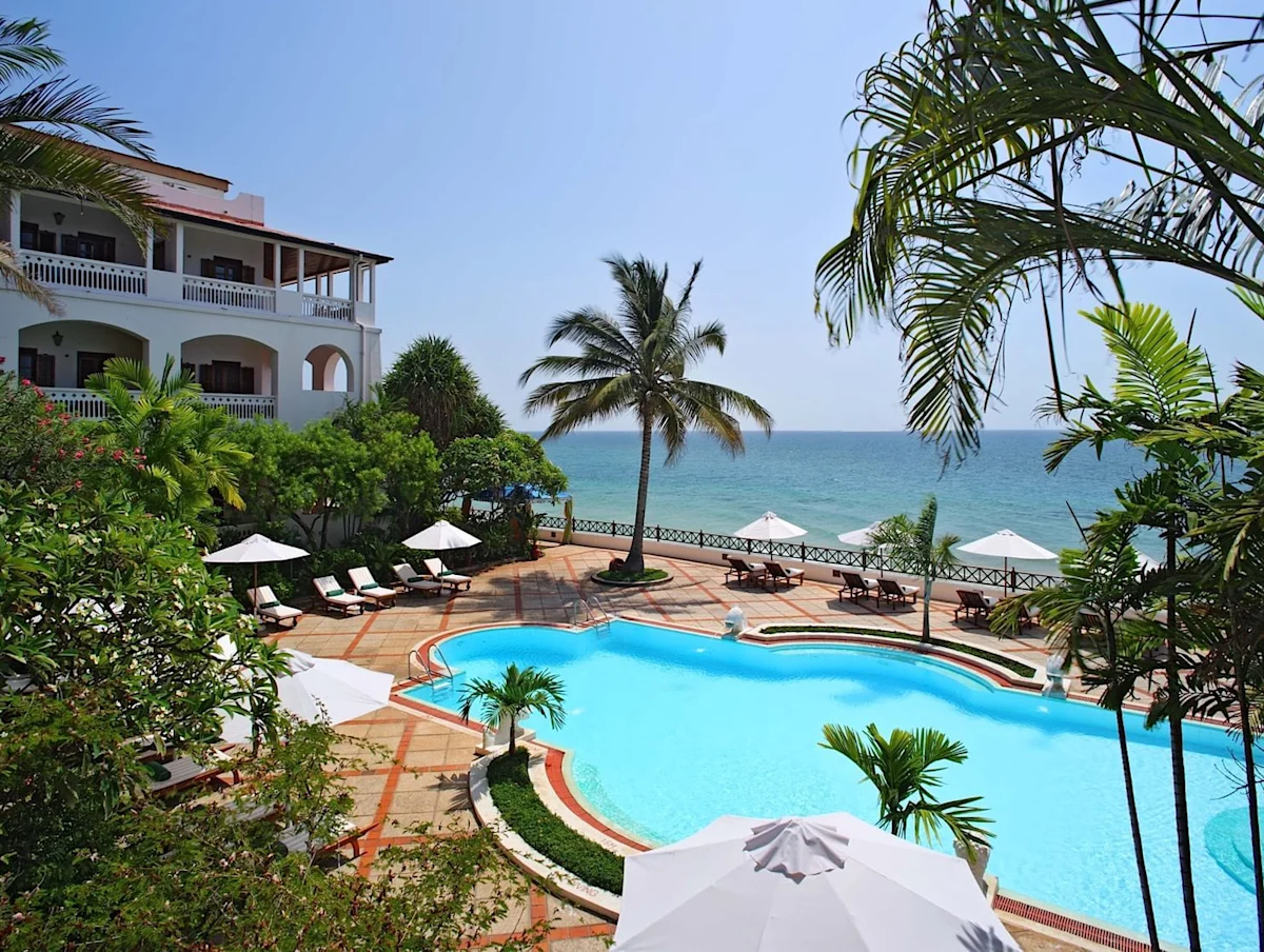 Pool and terrace lined with palms beside the sea at Zanzibar Serena Hotel