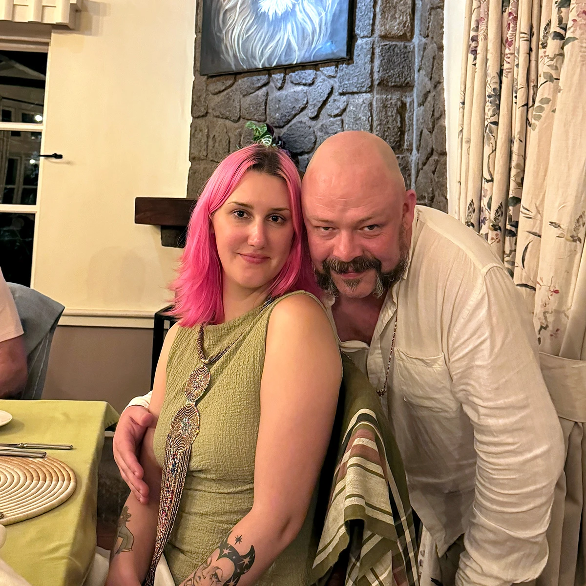Couple posing together at a dinner table in a lodge dining room