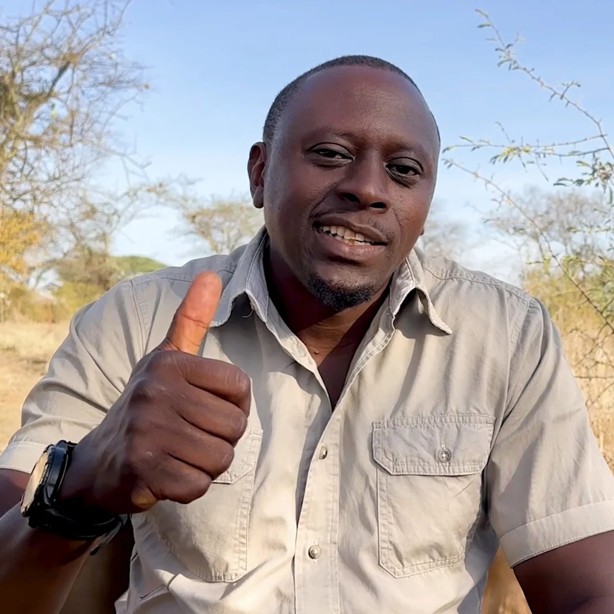 Safari guide Nasibu giving a thumbs-up in the bush