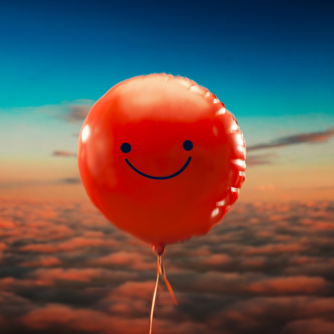 a smiling balloon, in front of a sunset