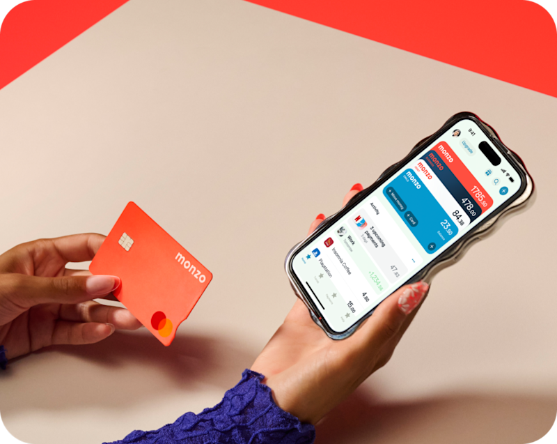 Image of a person holding their phone and looking at their Monzo app in one hand, and holding the hot coral card in their other hand. 
