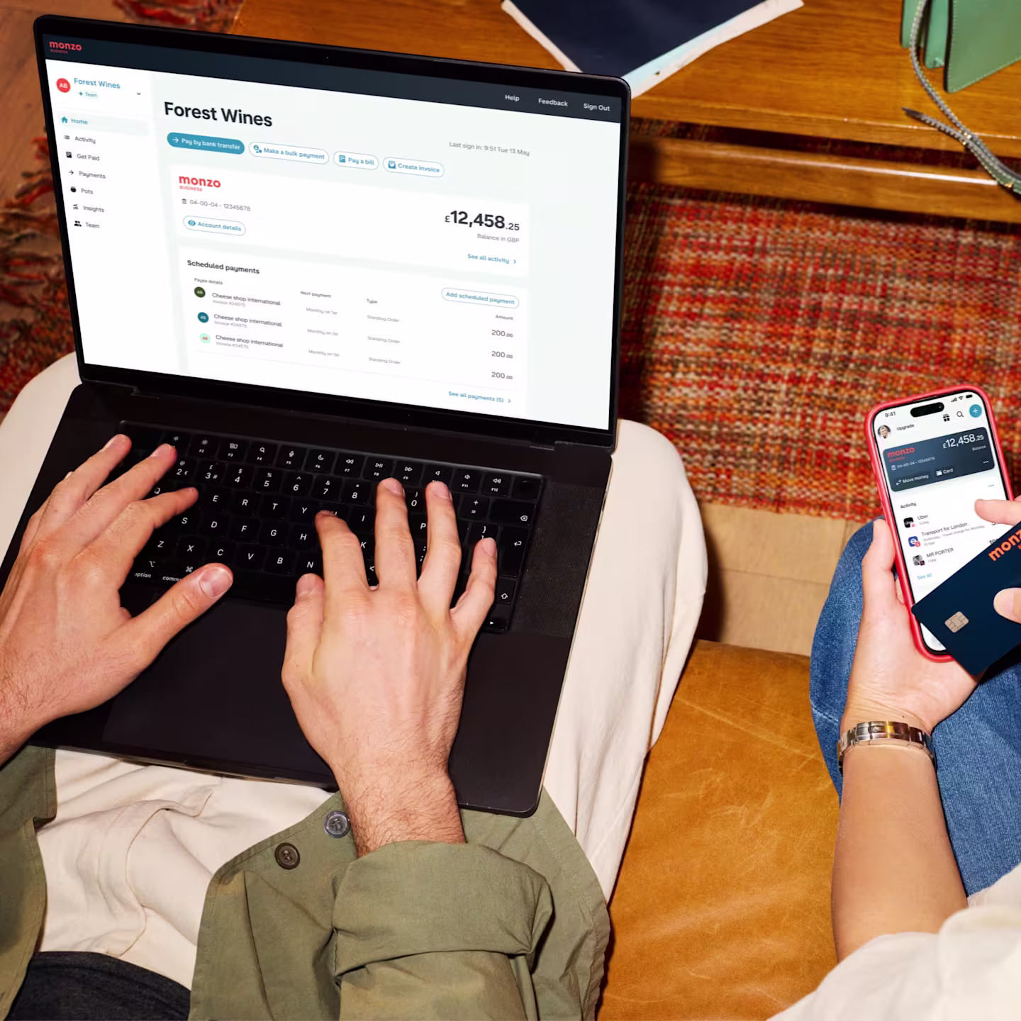 Two business colleagues with a laptop, a phone and a Monzo Business card