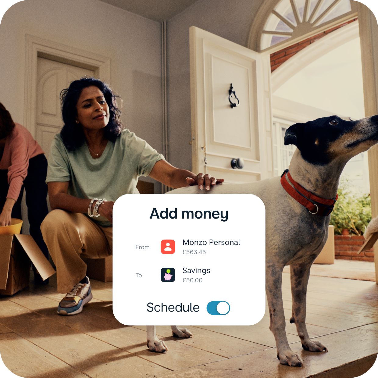 Women stroking her dog in her new home. Monzo app UI over the top showing her savings account. 