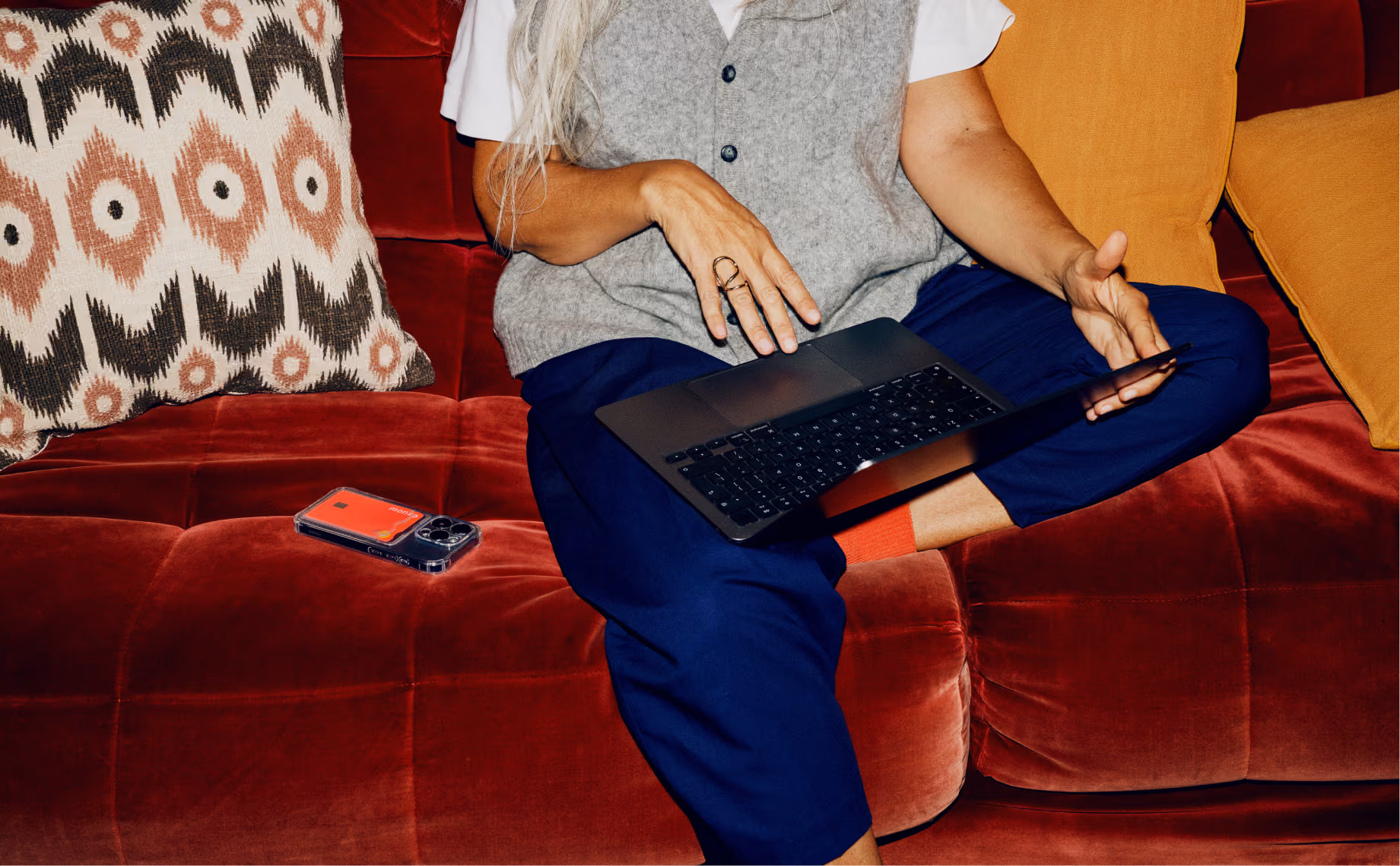 A woman sitting on a sofa using a laptop.