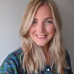 White woman with shoulder length blonde hair and a blue and green jumper