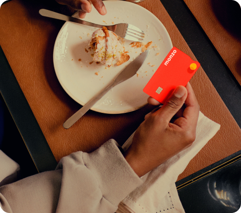 A person finishing a meal holding their hot coral card to pay. 