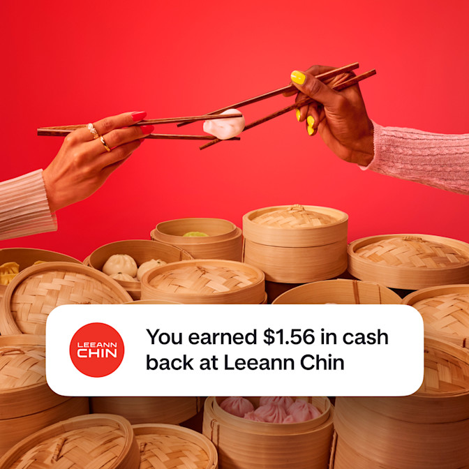 Two arms holding chopsticks with each pair of chopsticks holding onto the same dumpling against a red background. There is a celebration emoji with text saying You earned $1.56 in cash back at Leeann Chin.