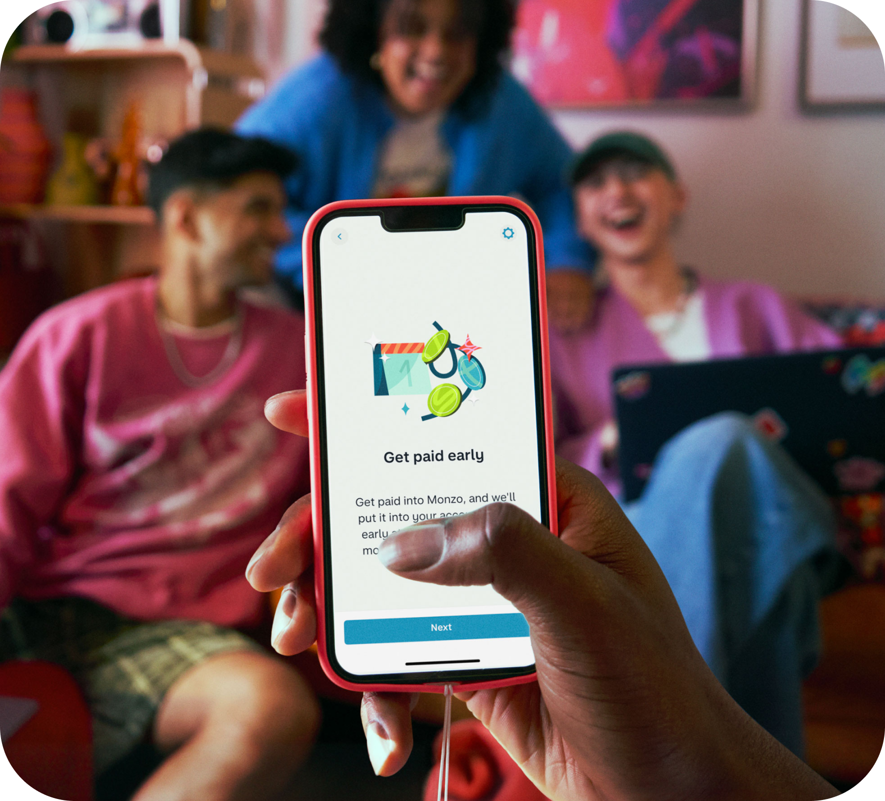 Point of view shot of phone with Get Paid Early app screen. Behind the phone are three friends socialising out of focus