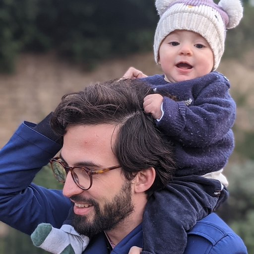 A picture of Aris with a baby on his shoulders