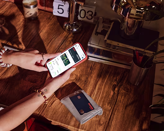 Mobile phone open on the Monzo business screen which Monzo debit card on the table